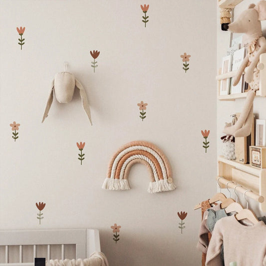 Nursery room with decorative rainbow and flowers on the wall, shelves with toys, and a crib.