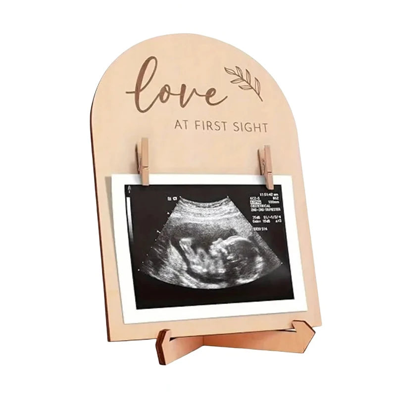 Wooden photo stand with ultrasound image and 'Love at First Sight' text on a white background