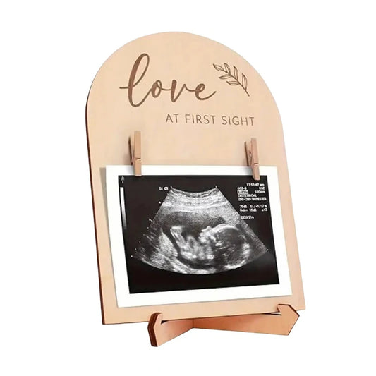 Wooden photo stand with ultrasound image and 'Love at First Sight' text on a white background